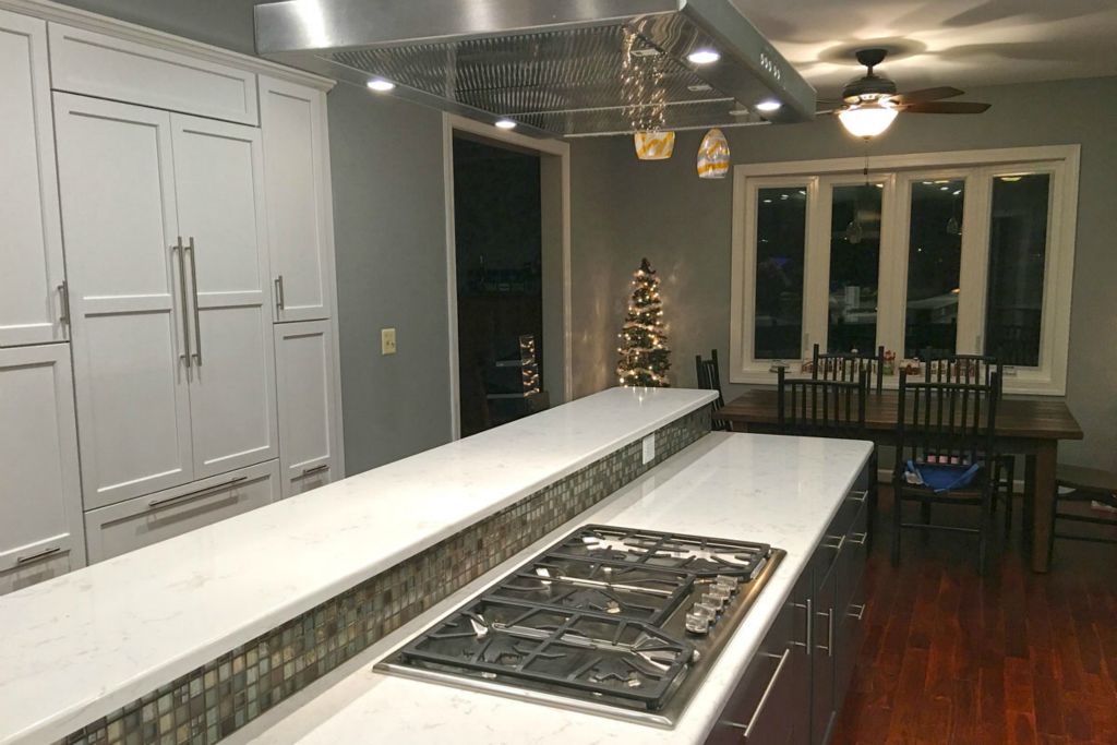 The long center island features a stainless steel 5-burner range with vent hood. 